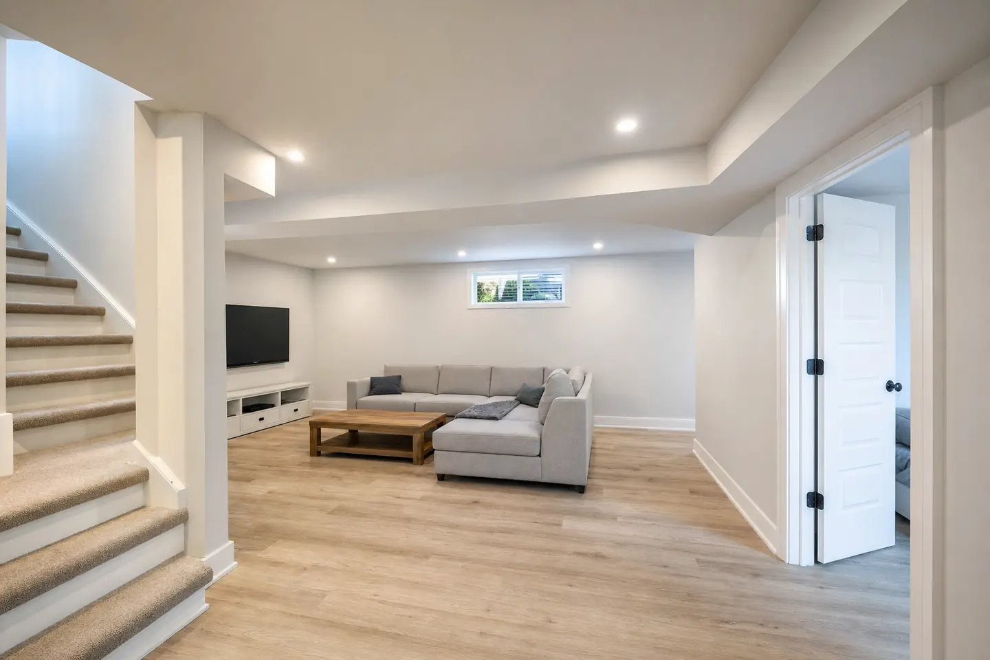 Basement after: An unfinished basement becomes a rec room, with headroom under the beam and an insulated perimeter.